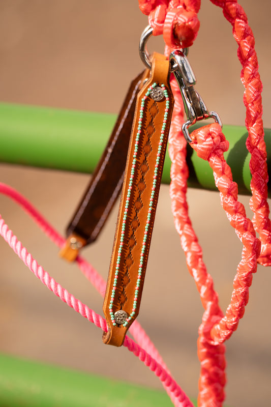 Neon pink hybrid halter with lariat nose band and hand stamped leather cheek pieces that have turquoise and neon pink beads on the border.